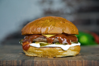 Булочка бриошь, котлета из говядины, кетчуп, двойной Чеддар, маринованный огурец, сливочный соус.