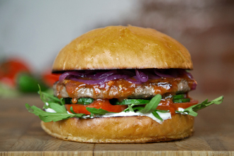 Булочка Бриошь, соус сливочный, салат Руккола, помидор, свежий огурец, котлета из говядины, соус Сацебели и маринованный лук.